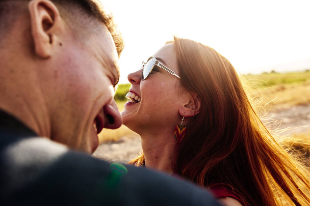 laughing girl and guy at sunset - Foto, afbeelding