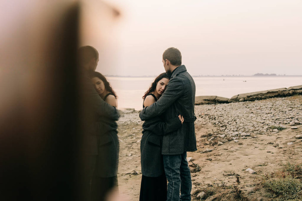 couple hugging by the ocean shore - 写真・画像