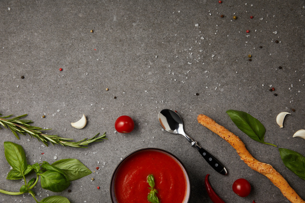 top view of plate with tasty tomato soup and fresh tomatoes on grey tabletop - Zdjęcie, obraz