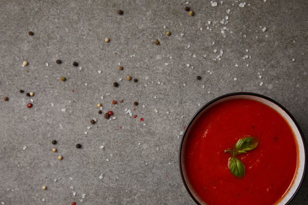 top view of tasty tomato soup and scattered spices on grey table - Fotoğraf, Görsel