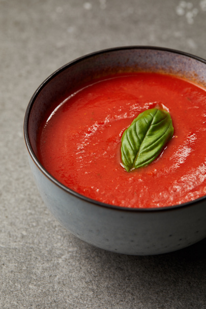 close up of plate with tasty tomato soup on grey table - Foto, afbeelding