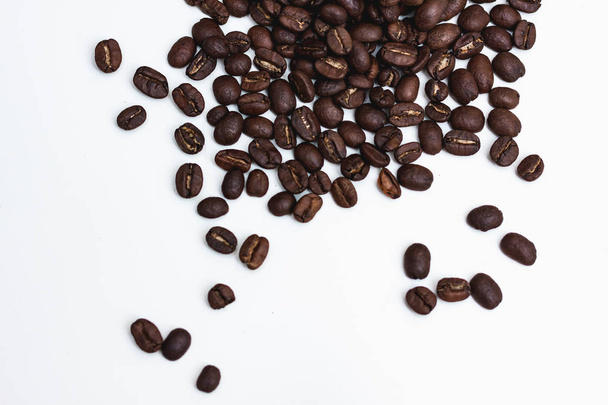 Various coffee beans spilled on a table - Valokuva, kuva