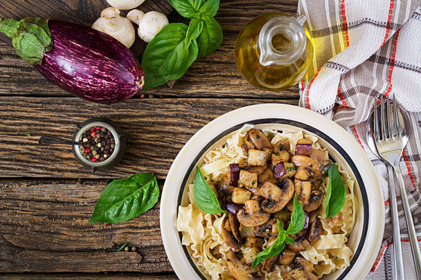 Vegetarian pasta with mushrooms and aubergines, eggplants. Italian food. Vegan meal. Top view. Flat lay. - Photo, Image