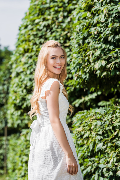 beautiful happy young blonde woman smiling at camera outdoors - Photo, Image