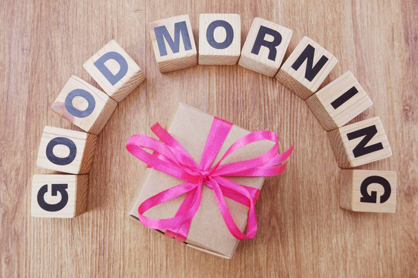 good morning alphabet letters with gift box present top view on wooden background - Φωτογραφία, εικόνα