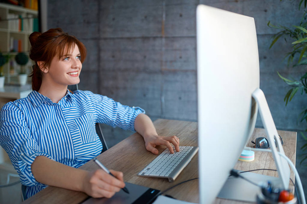 Smiling female entrepreneur freelancer working in office - Foto, imagen