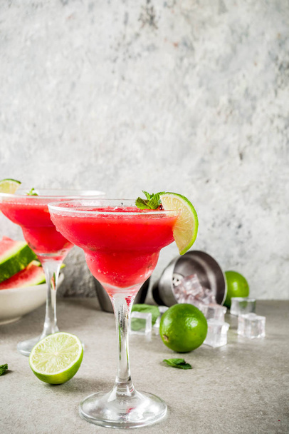 Watermelon margarita cocktail with lime and sliced watermelon, light concrete background copy space - Fotoğraf, Görsel