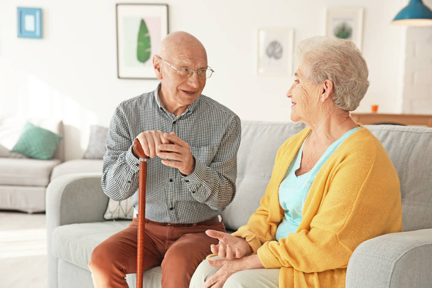 Elderly couple sitting on couch in living room - Foto, Imagem