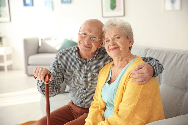 Idős házaspár ül a nappaliban a kanapén - Fotó, kép