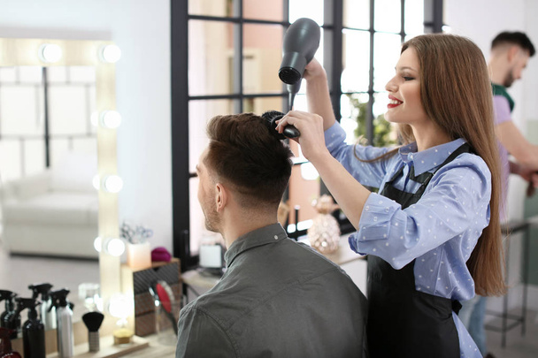 Professional hairdresser working with client in beauty salon - Fotoğraf, Görsel