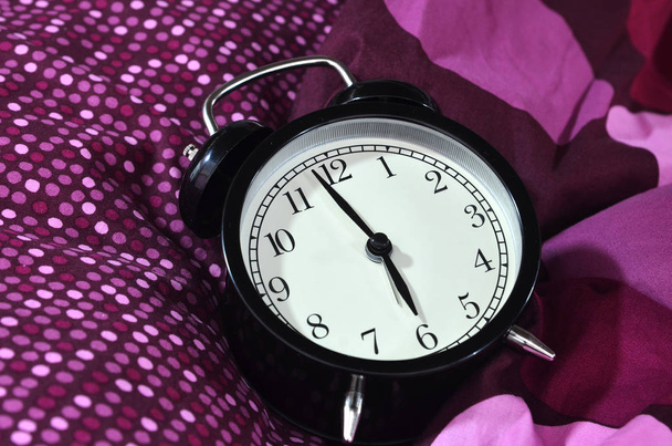Retro alarm clock in the morning on bed sheet - Photo, Image