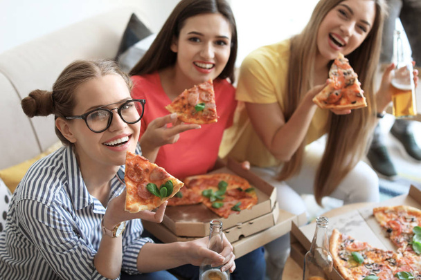 Jóvenes divirtiéndose con deliciosa pizza en el interior
 - Foto, Imagen