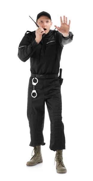 Male security guard using portable radio transmitter on white background - Foto, Imagen