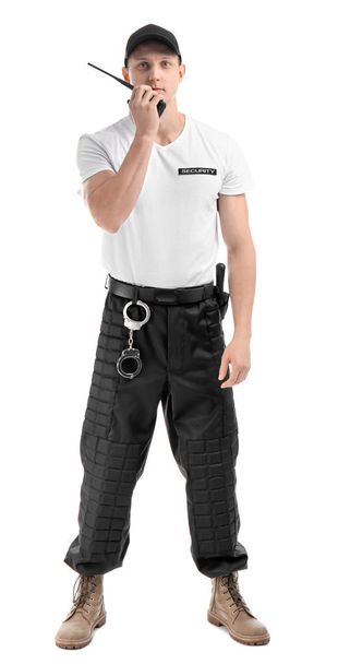 Male security guard using portable radio transmitter on white background - Foto, imagen