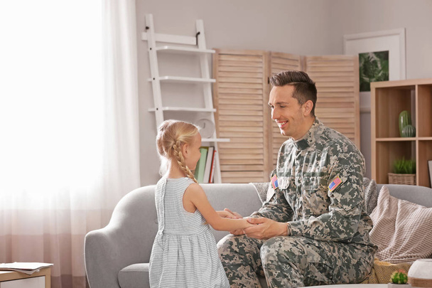 Young man in military uniform with his little daughter at home - Φωτογραφία, εικόνα