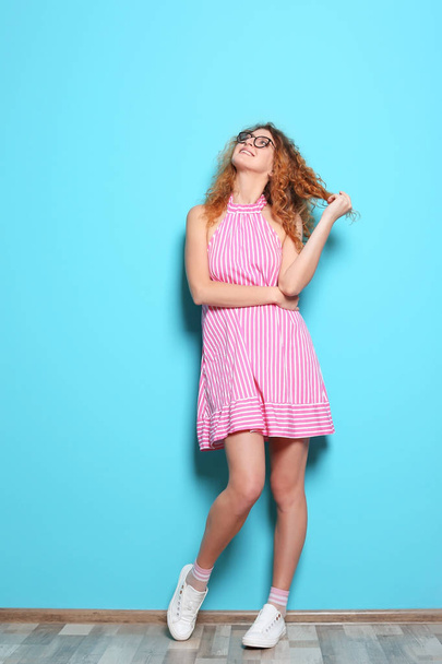 Full length portrait of beautiful woman with sexy legs near color wall - 写真・画像