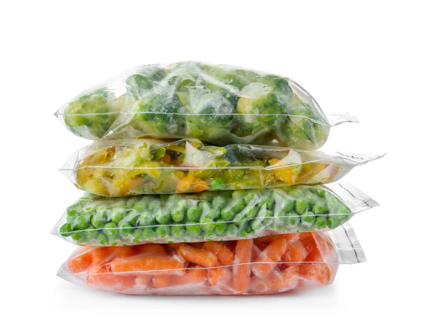 Plastic bags with frozen vegetables on white background - Valokuva, kuva