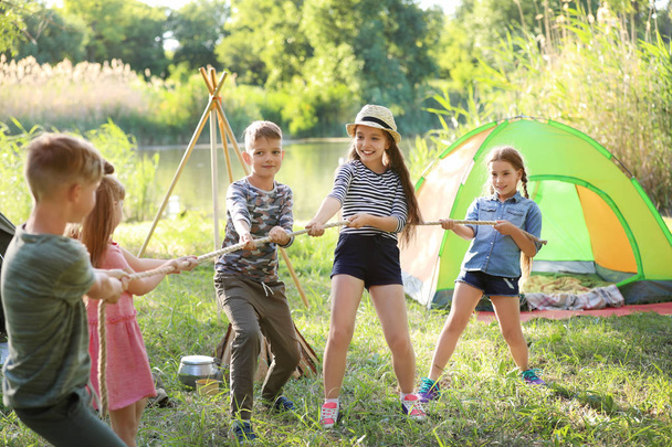 Little children pulling rope outdoors. Summer camp - Фото, изображение