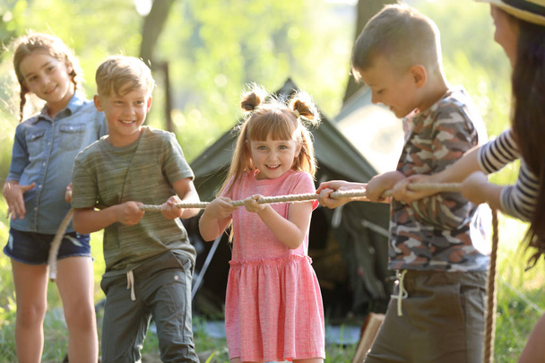 Little children pulling rope outdoors. Summer camp - Foto, Imagen