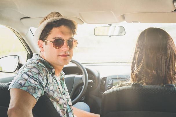Portrait of young hipster guy with his girlfriend in car. - Foto, imagen