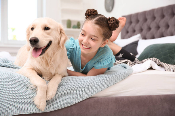 Cute little child with her pet on bed at home - Photo, image