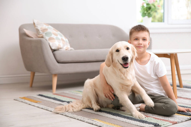 Cute little child with his pet on floor at home - Foto, imagen
