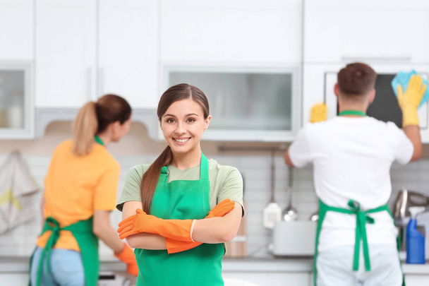 Team van professionele conciërges in uniform keuken schoonmaken - Foto, afbeelding