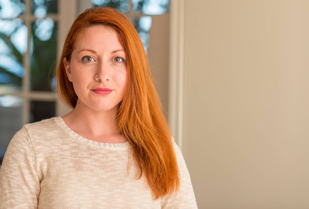 Redhead woman at home with a confident expression on smart face thinking serious - Photo, Image