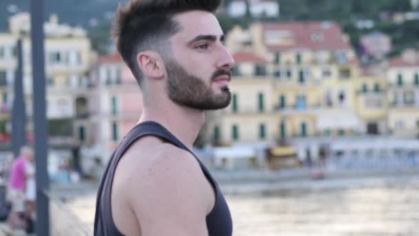 Attractive athletic young man on seaside promenade - Video