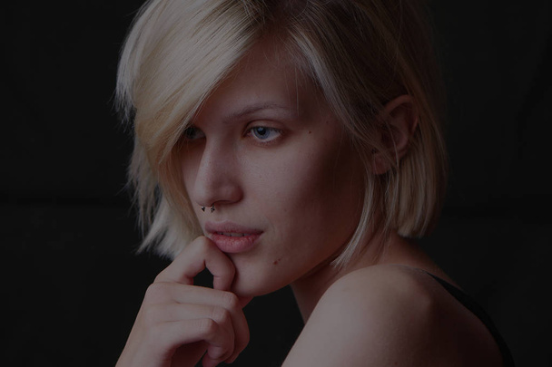 beautiful blonde woman with short hair and naked shoulders on dark background  - Foto, afbeelding