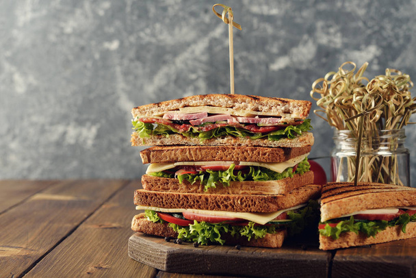 Sandwich with cucumber, cheese and ham on a brown background - Foto, immagini