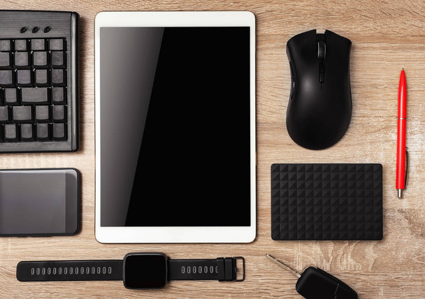 Tablette, smartphone, clavier, montres intelligentes, souris d'ordinateur sur la table en bois
. - Photo, image