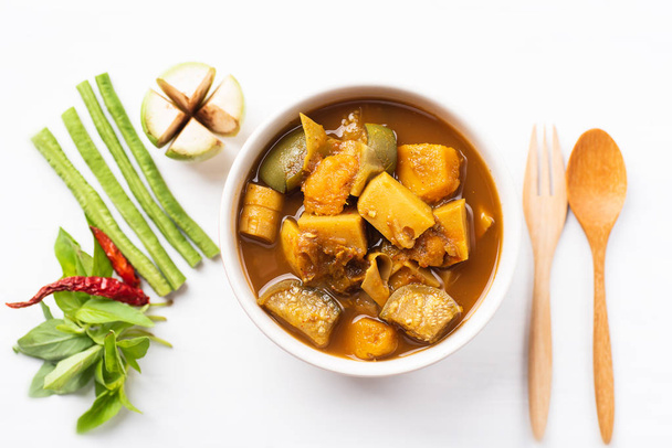 Рыбные органы кислый суп (Kaeng Tai Pla) в миске и овощах, вид сверху, южная тайская кухня
 - Фото, изображение