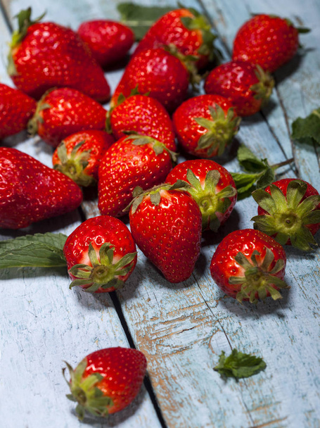 Fresh juicy strawberries with leaves on blue wooden background. Strawberry. - Valokuva, kuva