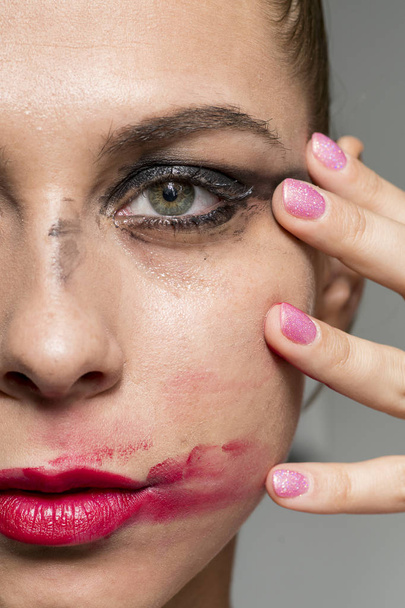 Sad crying girl smearing red lipstick looking into camera glamour shot - Photo, Image