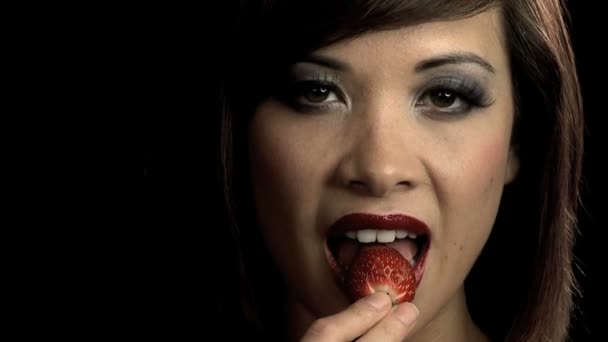 sinnliche westliche orientalische Mädchen langsam in eine Erdbeere beißen - Filmmaterial, Video