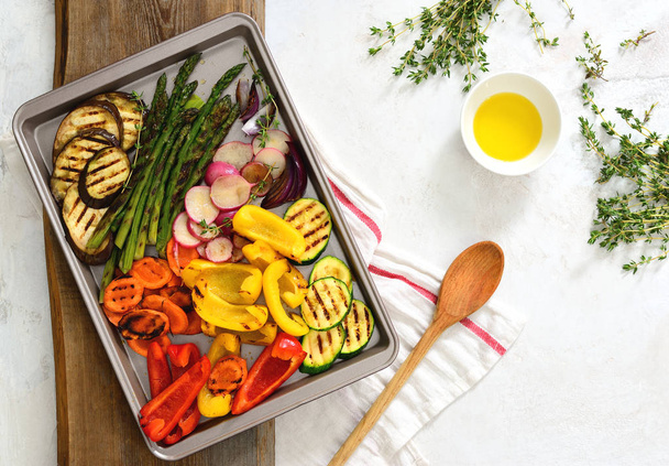 Repas végétarien simple, légumes rôtis sur une feuille avec huile d'olive et thym, vue aérienne
 - Photo, image