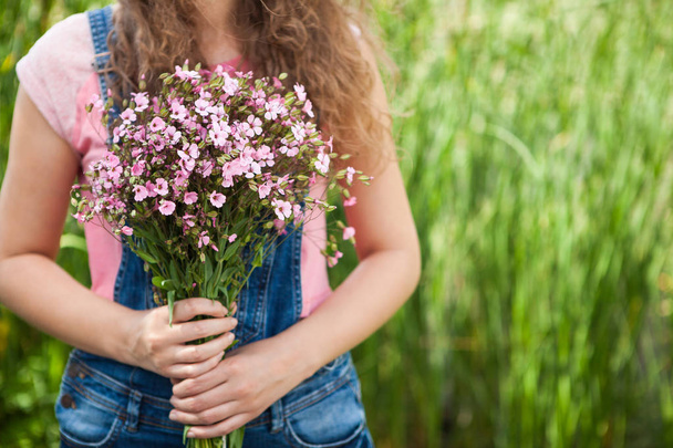 Young woman with pink flowers as gift, Happy birthday or anniversary concept etc - Foto, imagen