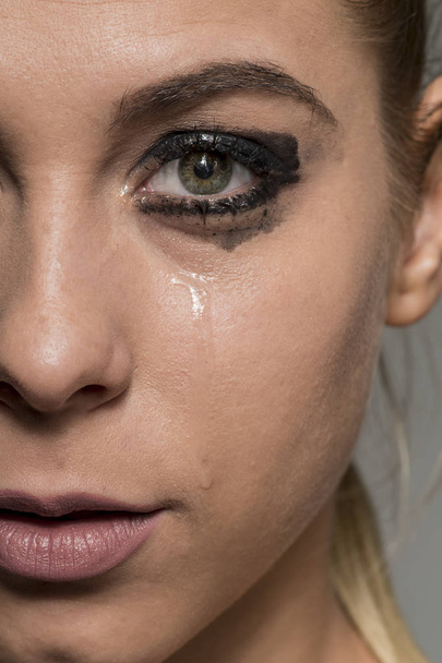 Θλιβερή κλαίει κορίτσι ψάχνει σε κάμερα με αλείψει μακιγιάζ - Φωτογραφία, εικόνα