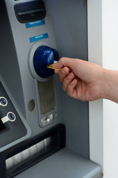 Działalności człowieka umieścić jego karty kredytowej w bankomacie  - Zdjęcie, obraz