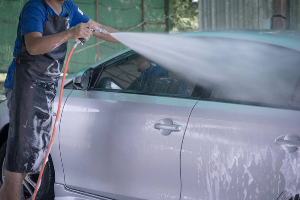 Mitarbeiter waschen Autos, damit das Auto glänzt, das Auto sauber ist verschwommen - Foto, Bild