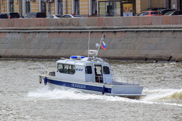 Moscow, Russia - June 21, 2018: Police boat rushing along water surface on a background of Moskva river embankment on a sunny summer day - Fotografie, Obrázek