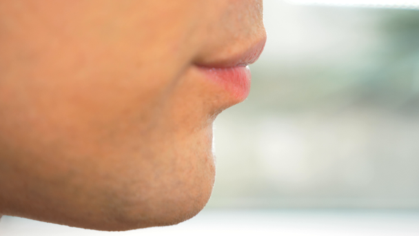 Nahaufnahme. männliche Lippen im Profil. Ein Mann isst Essstäbchen, einen Salat aus frischen Gurken mit Kräutern. 4k, Zeitlupe. - Filmmaterial, Video