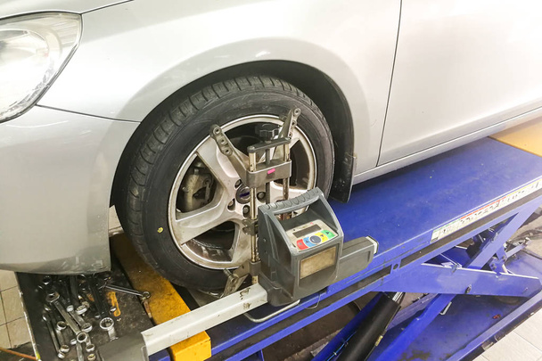 Car undergo wheel align in garage with precision alignment equipment - Photo, Image