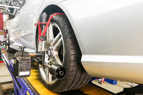 Car undergo wheel align in garage with precision alignment equipment - Photo, Image
