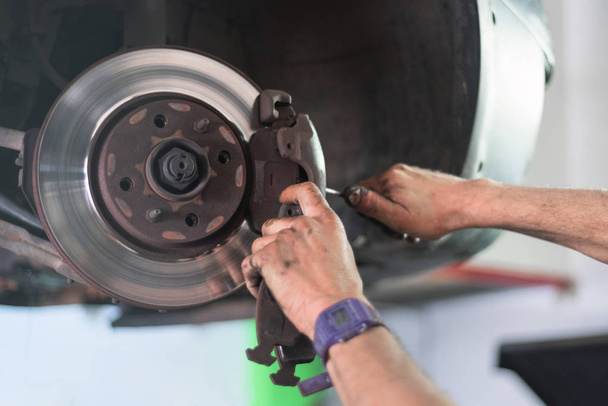 Close up of car mechanic repairing brake pads - Fotoğraf, Görsel