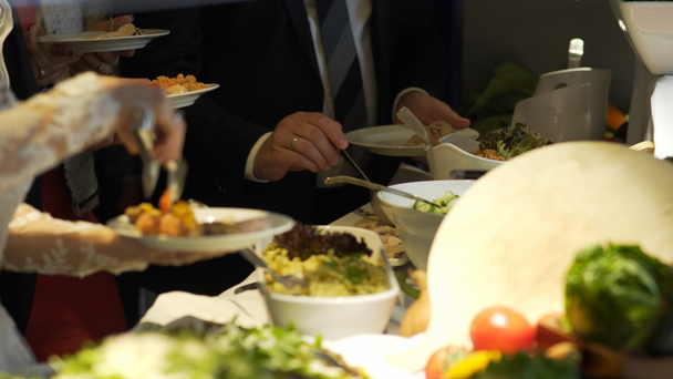 Os hóspedes do restaurante selecionam comida de um buffet
 - Filmagem, Vídeo