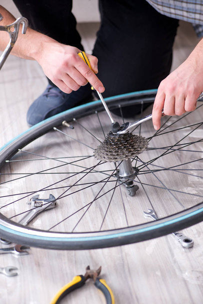 家で自転車を修理する若い男 - 写真・画像