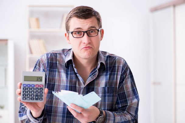 Mladý muž frustrovaný z jeho domu a daňových účtů - Fotografie, Obrázek