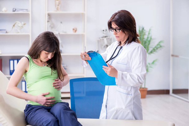 Pregnant woman visiting doctor for regular check-up - Фото, изображение